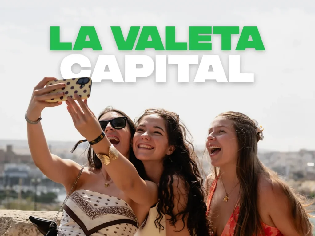 Tres chicas haciéndose un selfie con La Valeta de fondo