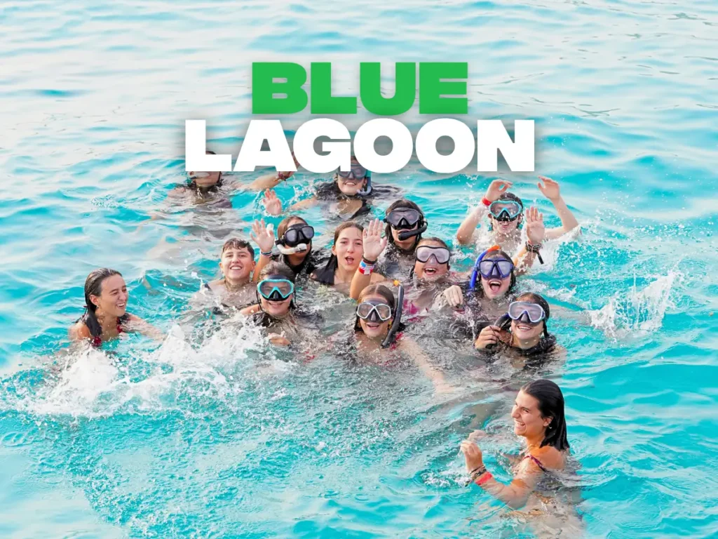 Grupo de jóvenes bañándose con gafas de buceo en las aguas turquesa del Blue Lagoon de Comino, Malta