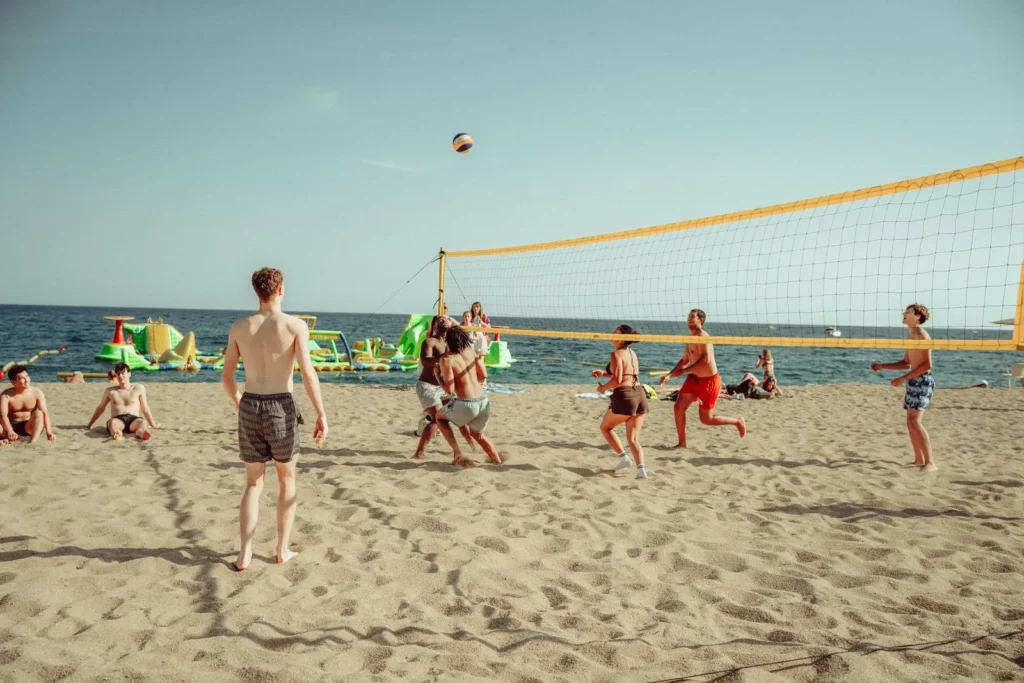 Jóvenes jugando un partido de vóley playa en la costa mediterránea española