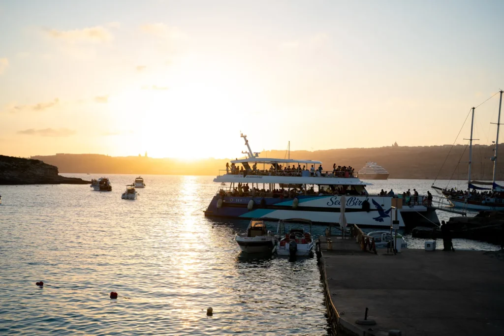 Atardecer en la Blue Lagoon de Comino con barcos fondeados, excursión del viaje a Malta