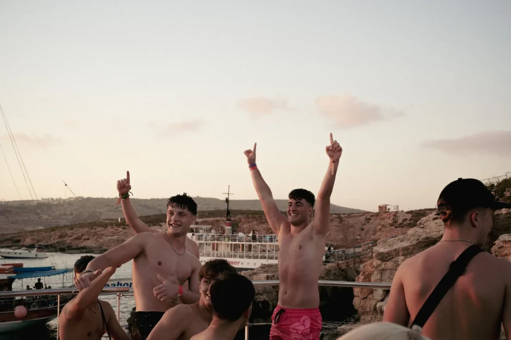 Grupo de chicos celebrando en el barco rumbo a Comino en su viaje de fin de carrera a Malta